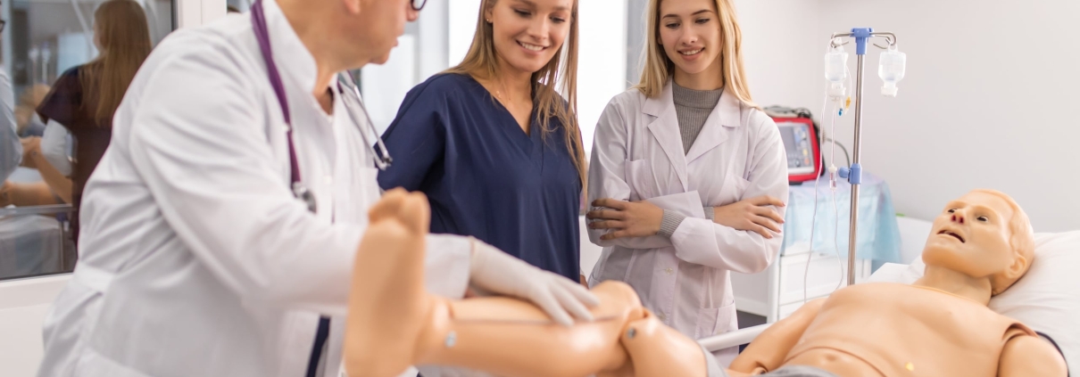 Two students working with an instructor in the simulation lab