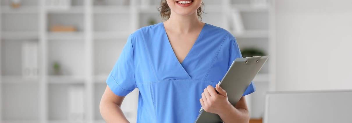Smiling medical professional with a clipboard in scrubs