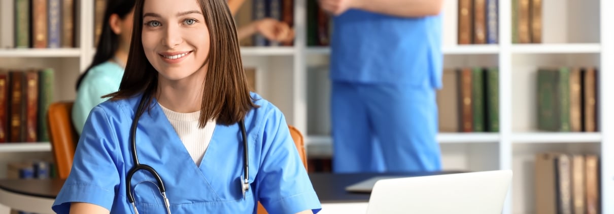 Nursing student using a laptop in a school library