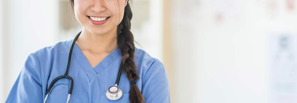 Asian nurse smiling with her arms crossed